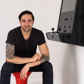 Animator Preston McNeil with an arcade game console created in collaboration with artist Joe Sheehan