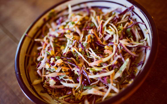Image of a bowl of cabbage and carrot slaw in a mayonnaise dressing.