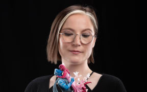 Lore Olympus creator Rachel Smythe with the 'Hades and Persephone kissing' collectible created in collaboration with Wētā Workshop