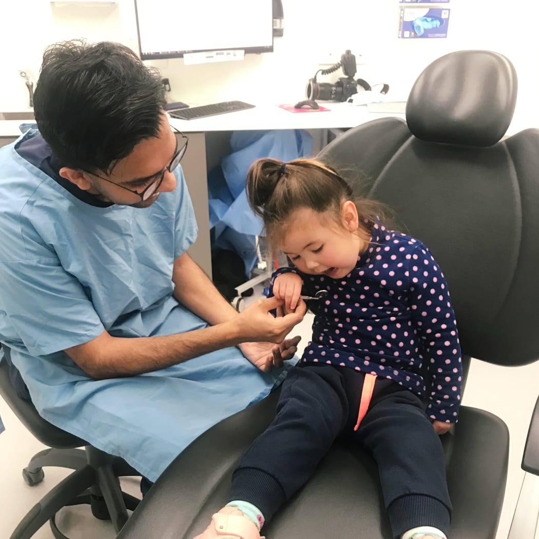 A young girl gets her teeth checked