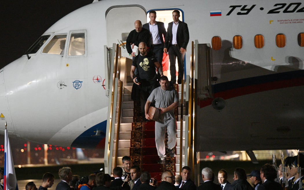 In this pool photograph distributed by Russian state agency Sputnik, Russian citizens released in a major prisoner swap with the West, disembark from a plane at Moscow's Vnukovo airport on 1 August, 2024.
