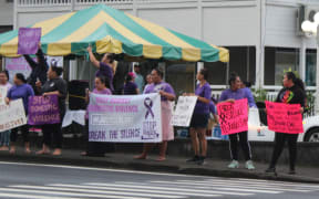 Supporters line the road in downtown Fagatogo during a rally against domestic violence