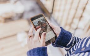 A woman using the Instagram app on her cellphone.
