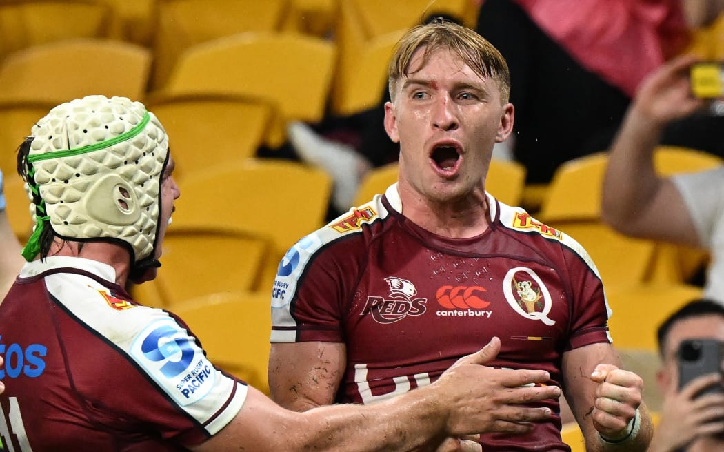 Tate McDermott (right) of the Reds celebrates scoring a try.