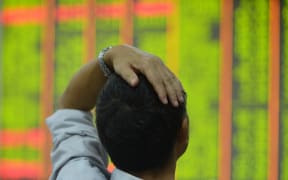 A customer pays attention to the stock market at a stock exchange in Hangzhou, east China's Zhejiang province.
