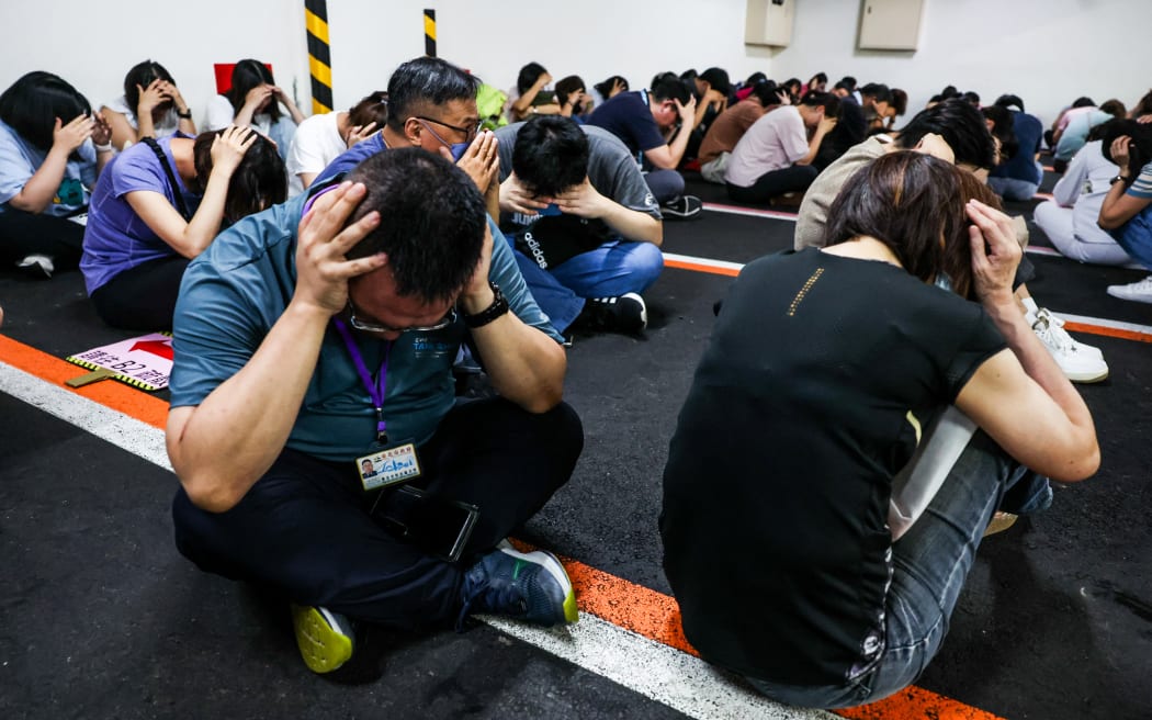 People take shelter during an air raid drill coinciding with the Han Kuang military exercises in Taipei on July 17, 2025. The annual civilian drill is being held in cities across Taiwan this week, alongside military training, to prepare the self-governed island for a potential Chinese invasion. (Photo by I-Hwa Cheng / AFP) / “The erroneous mention[s] appearing in the metadata of this photo by I-Hwa Cheng has been modified in AFP systems in the following manner: [Han Kuang military exercises] instead of [Kan Huang military exercises]. Please immediately remove the erroneous mention[s] from all your online services and delete it (them) from your servers. If you have been authorized by AFP to distribute it (them) to third parties, please ensure that the same actions are carried out by them. Failure to promptly comply with these instructions will entail liability on your part for any continued or post notification usage. Therefore we thank you very much for all your attention and prompt action. We are sorry...