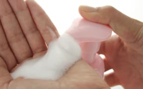Hand soap being squeezed onto a pair of hands