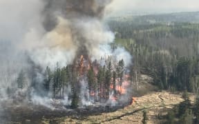This handout image courtesy Manitoba Government shows a wildfire burning near Lac-du-Bonnet on May 14, 2025 in Manitoba, a province in central Canada experiencing unusually hot, dry and windy conditions. Two people died after being trapped by the wildfire in the rural municipality of Lac du Bonnet. (Photo by Handourt / Manitoba Government / AFP) / RESTRICTED TO EDITORIAL USE - MANDATORY CREDIT "AFP PHOTO /  MANITOBA GOVERNMENT/ HO- HANDOUT - NO MARKETING NO ADVERTISING CAMPAIGNS - DISTRIBUTED AS A SERVICE TO CLIENTS