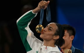 Gold medallist Algeria's Imane Khelif poses on the podium during the medal ceremony for the women's 66kg final boxing category during the Paris 2024 Olympic Games at the Roland-Garros Stadium, in Paris on August 9, 2024. (Photo by Mauro PIMENTEL / AFP)