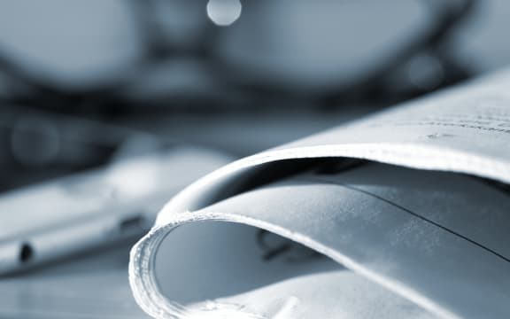 118815655 - a newspaper, reading glasses and a smartphone