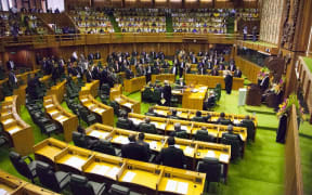 Members of parliament stand to the right of the speaker (R) to approve the vote of Peter O'Neill as prime minister in Port Moresby on August 3, 2012.