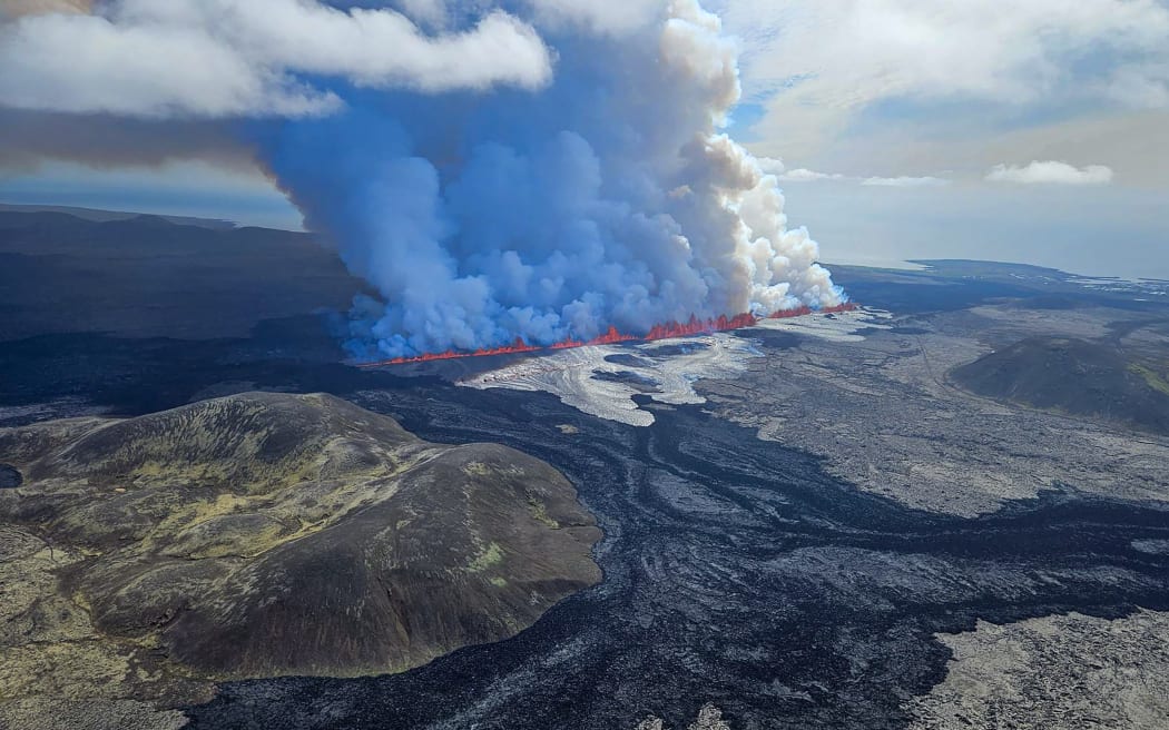 This handout picture released by the Icelandic Coast Guard on May 29, 2024 shows billowing smoke and flowing lava pouring out of a new fissure, during a surveilance flight above a new volcanic eruption on the outskirts of the evacuated town of Grindavik, western Iceland. A new volcanic eruption has begun on the Reykjanes peninsula in southwestern Iceland, the country's meteorological office said Wednesday, shortly after authorities evacuated the nearby town of Grindavik. (Photo by HANDOUT / Icelandic Coast Guard / AFP) / RESTRICTED TO EDITORIAL USE - MANDATORY CREDIT "AFP PHOTO /HANDOUT/ICELANDIC COAST GUARD " - NO MARKETING - NO ADVERTISING CAMPAIGNS - DISTRIBUTED AS A SERVICE TO CLIENTS