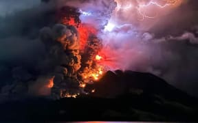 This handout photograph taken and released by the Center for Volcanology and Geological Hazard Mitigation on April 17, 2024, shows Mount Ruang spewing hot lava and smoke as seen from Sitaro, North Sulawesi. A volcano erupted several times in Indonesia's outermost region overnight on April 17, forcing hundreds of people to be evacuated after it spewed lava and a column of smoke more than a mile into the sky. (Photo by Handout / Center for Volcanology and Geological Hazard Mitigation / AFP) / RESTRICTED TO EDITORIAL USE - MANDATORY CREDIT AFP PHOTO / CENTER FOR VOLCANOLOGY AND GEOLOGICAL HAZARD MITIGATION/ PVMBK - NO MARKETING - NO ADVERTISING CAMPAIGNS- DISTRIBUTED AS A SERVICE TO CLIENTS