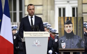 Etienne Cardiles gave a moving address at the ceremony of remembrance for his  partner, policeman Xavier Jugele, whose portrait is placed by his side.