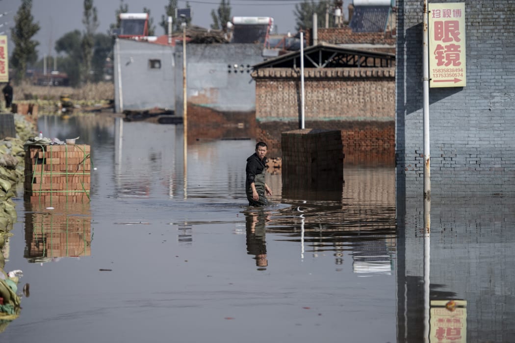 A man makes his way along a flooded area after heavy rainfall in Jiexiu in the city of Jinzhong in China's northern Shanxi province on 11 October 2021.