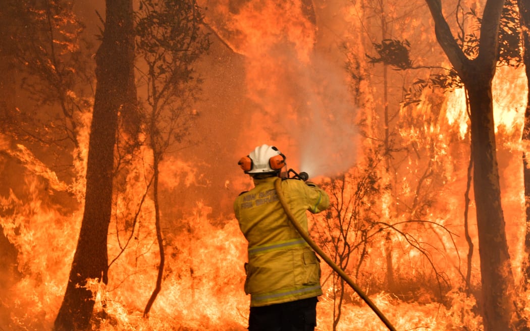 A firefighter conducts back-burning measures to secure residential areas from encroaching bushfires in the Central Coast, some 90-110 kilometres north of Sydney on December 10, 2019.