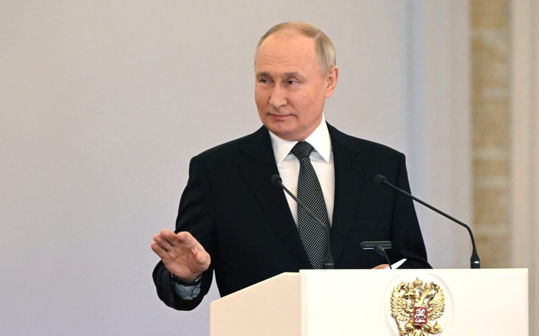 This pool photograph distributed by Russian state agency Sputnik shows Russia's President Vladimir Putin attending a ceremony to present Gold Star medals to Heroes of Russia on the eve of the Heroes of the Fatherland Day at the St. George Hall of the Grand Kremlin Palace in Moscow on 8 December, 2023. Russian leader Vladimir Putin has decided to run in presidential elections next March, news agencies reported on 8 December, 2023, allowing the Kremlin leader to extend his decades-long grip on power. Putin told Lieutenant Colonel Artyom Zhoga, a Russian military officer, about his decision to participate in the upcoming vote following an awards ceremony for army personnel at the Kremlin, state-run news agencies reported.