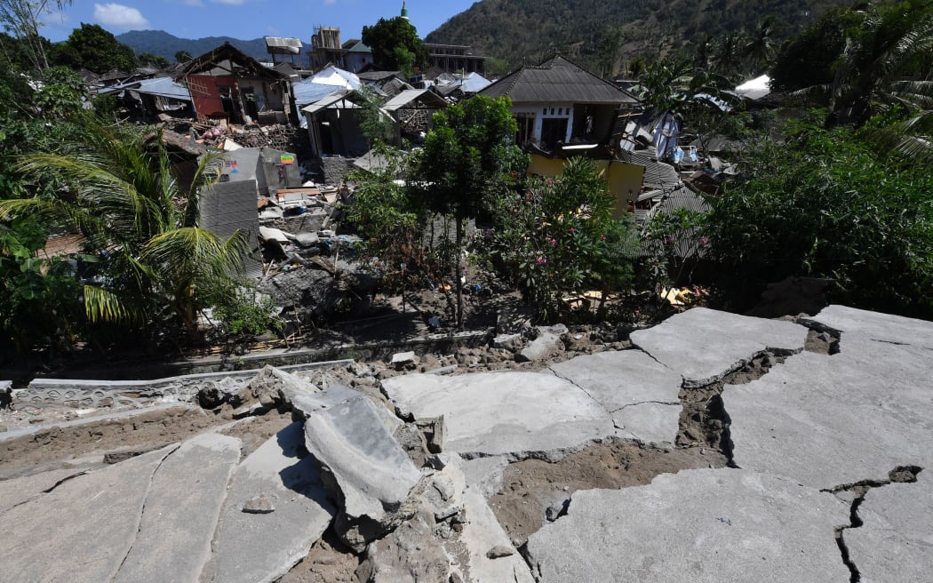 Cracked concrete and damaged houses are pictured in Pemenang in northern Lombok