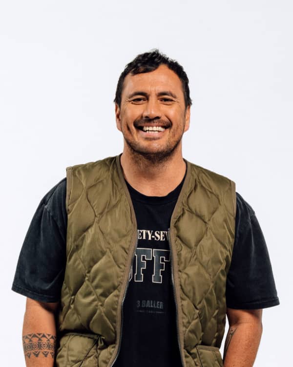 Tammy Davis is a smiling bearded man in a shiny green vest and black t-shirt.