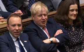 A video grab shows Britain's Prime Minister Boris Johnson (C) reacting after his Government won the vote on the third reading of the European Union (Withdrawal Agreement) Bill, in the House of Commons in London on January 9, 2020.