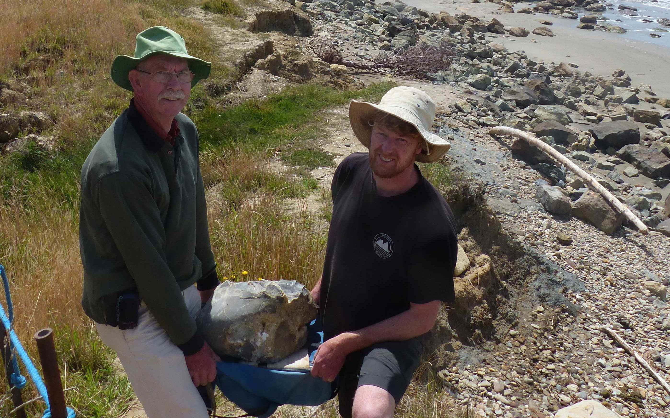 Preparator Al Mannering and curator Alan Tennyson at the beach where the rock was found.