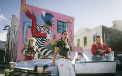 Dreamgirls Art Collective in front of their mural at the intersection of Ghuznee and Leeds Streets in Wellington.