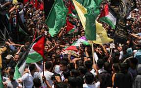 Palestinian mourners carry the body of 21 years old Razan al-Najjar during her funeral after she was shot dead by Israeli soldiers, in Khan Yunis on June 2, 2018.