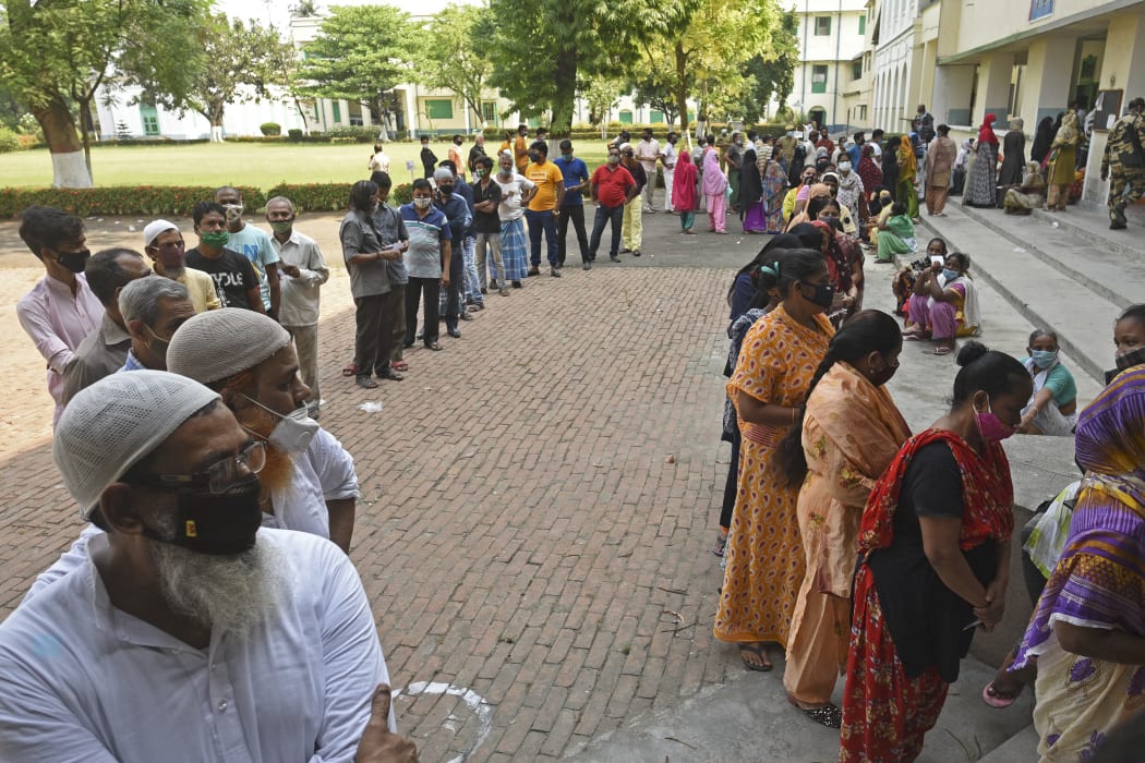 Voters queue up to cast their ballot during the final phase of West Bengal's state legislative assembly elections in Kolkata, India on 29 April 2021.