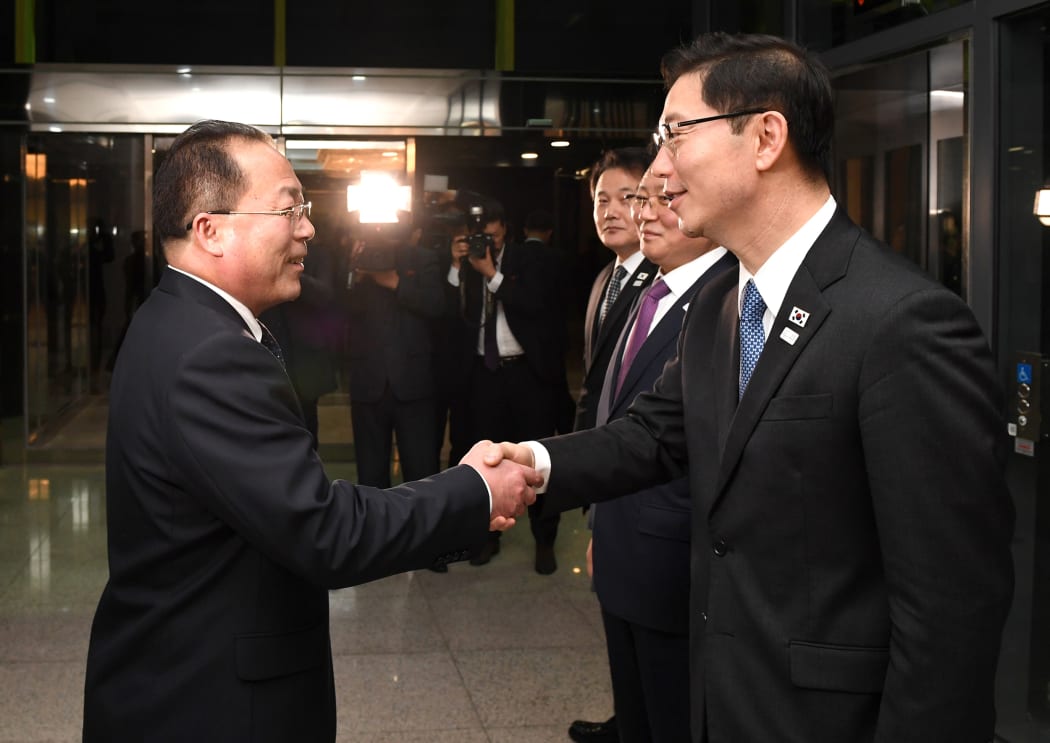 This handout photo provided by South Korean Unification Ministry on January 17, 2018 shows South Korean chief delegate Chun Hae-Sung (R) shaking hands with North Korean chief delegate Jon Jong-Su (L) after their working-level talks.