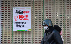 A man walks past a poster saying ibuprofen sold out today at a pharmacy amid the Covid-19 pandemic in Nanjing, in China's eastern Jiangsu province on 20 December.