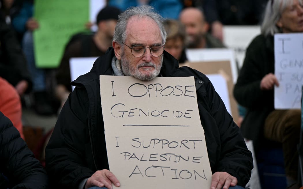 A protester holds a placard at a "Lift The Ban" demonstration in support of the proscribed group Palestine Action, calling for the recently imposed ban to be lifted, in Trafalgar Square, central London, on October 4, 2025. (Photo by JUSTIN TALLIS / AFP)