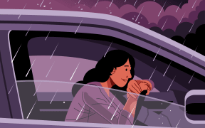 A person sitting in their car in a downpour of a thunderstorm, bad weather, rain.