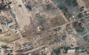 This handout satellite photo taken and released by Planet Labs PBC on July 12, 2022, shows the aftermath after artillery fire on a site in Nova Kakhovka, in the southern Ukrainian region of Kherson occupied by Russian forces. - Kyiv said on July 12, 2022, it has destroyed an arms depot as part of a barrage of rockets and missiles on Russian military targets in southern Ukraine. Ukrainian military officials say the strikes in the Kherson region destroyed artillery, armoured vehicles "and a warehouse with ammunition in Nova Kakhovka". (Photo by Handout / Planet Labs PBC / AFP) / RESTRICTED TO EDITORIAL USE - MANDATORY CREDIT "AFP PHOTO / PLANET LABS PBC" - NO MARKETING - NO ADVERTISING CAMPAIGNS - DISTRIBUTED AS A SERVICE TO CLIENTS