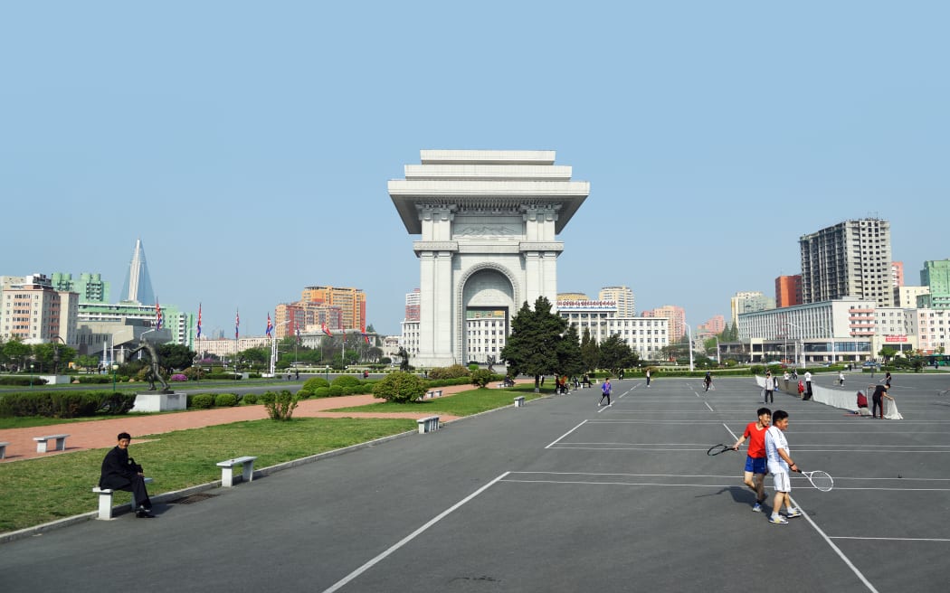 Pyongyang, North Korea - May 1, 2019: People play tennis next to Arch of Triumph. A monument built in Pyongyang in honor of the Korean resistance of 1925-1945 against the Japanese occupiers