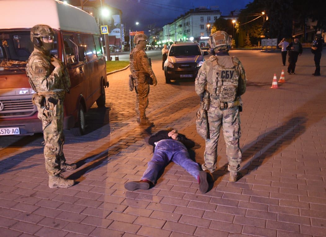 The suspect in the hostage situation lies on the ground after being detained by law enforcement officers in the city of Lutsk, Ukraine, on July 21, 2020.