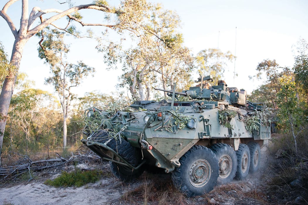 A New Zealand Defence Force tank driving through the bush.