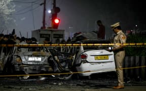 A police personnel inspects charred vehicles at the blast site after an explosion near the Red Fort in the old quarters of Delhi on 10 November, 2025.