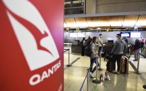 Travelers wait in line after verifying their Covid-19 vaccination status as they check-in for a flight to Sydney.