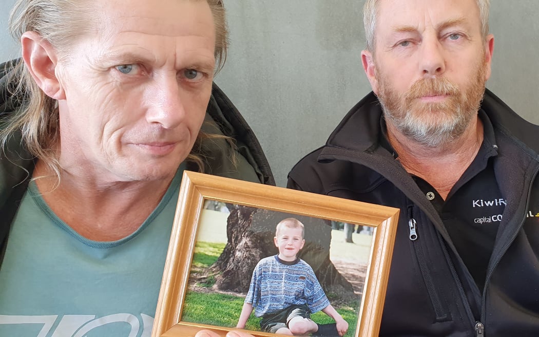 Mark Ginders, left, with a photo of his son Jake when he was younger, and Jake's uncle Wayne Ginders (right).