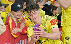 Defender Isaac Hughes poses for a photo with a Phoenix fan.
