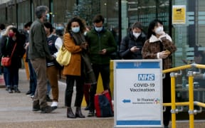 People queue to receive coronavirus vaccines in front of the St. Thomas Hospital due to the increase in cases of the Omicron variant of the COVID-19 in London, United Kingdom