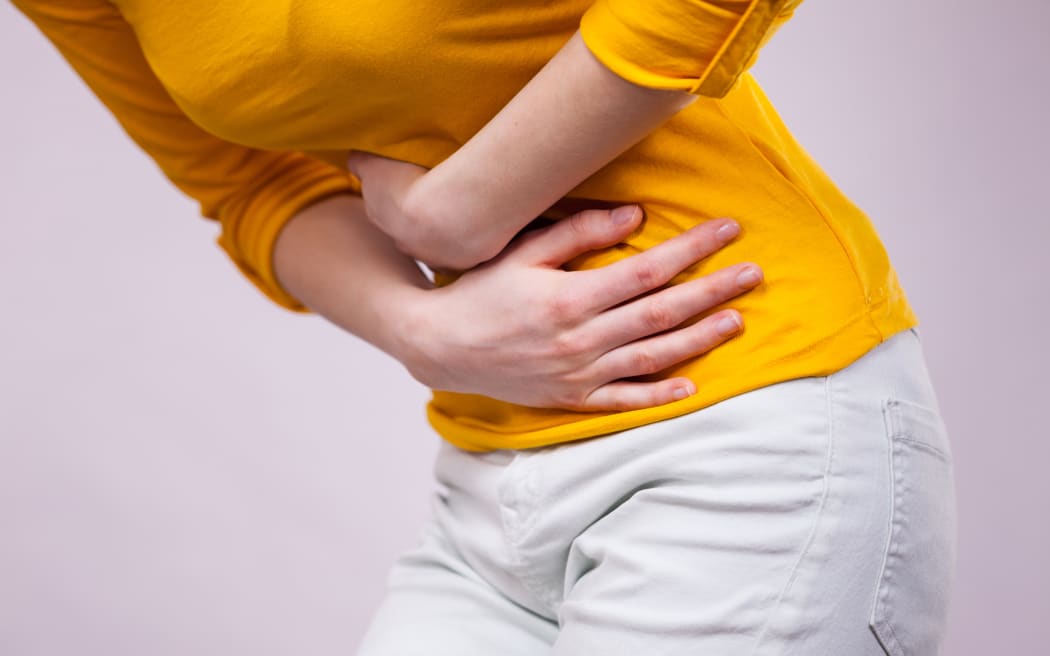 Health care concept. Bellyache, indigestion or menstruation. Young female suffering from strong stomach ache abdominal pain.