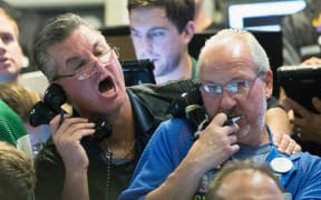 Traders at the Chicago Board Option Exchange work as big losses in the Asian market rock stocks.