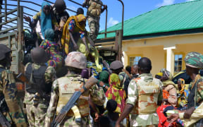 Soldiers assist people rescued from Boko Haram camps in Maiduguri, Borno State, on July 30, 2015. AFP PHOTO / STRINGER