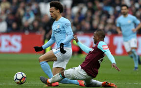 West Ham defender Patrice Evra tackles Manchester City's Leroy Sane.