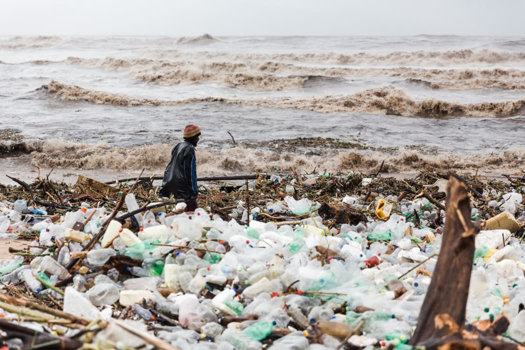 A man is seen searching through debris at the Blue Lagoon beach following heavy rains and winds in Durban, on April 12, 2022.
