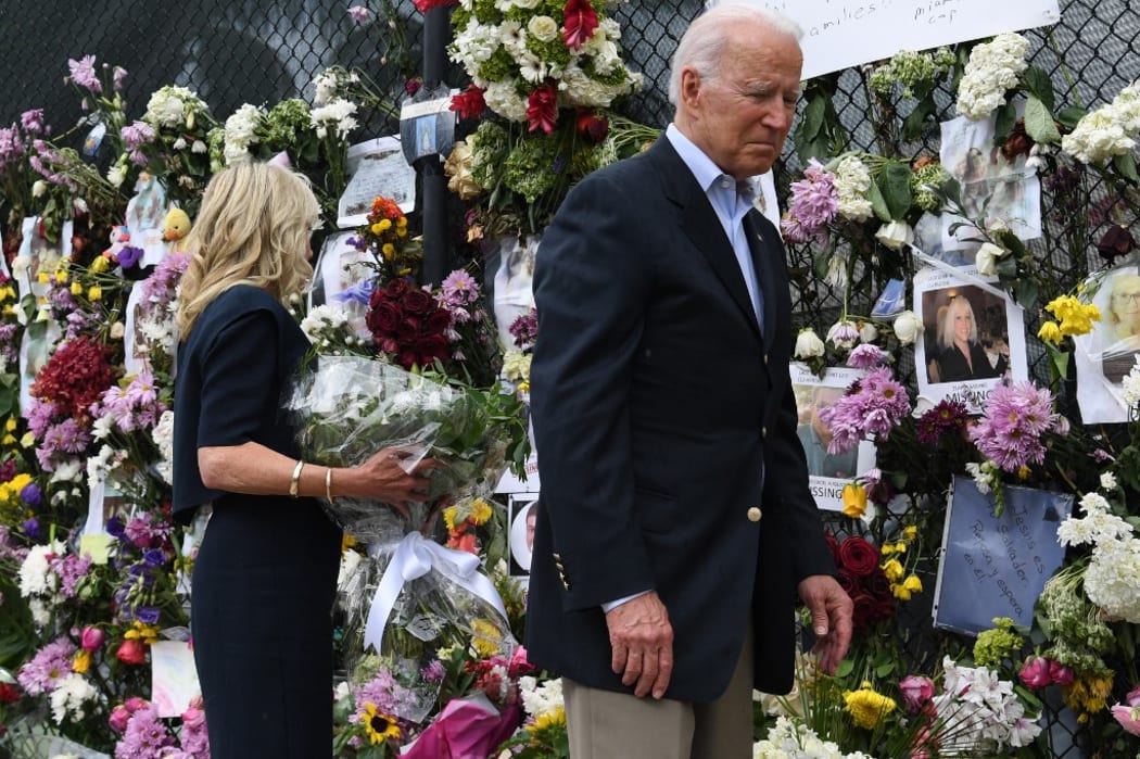 US President Joe Biden and US First Lady Jill Biden visit a photo wall, the 'Surfside Wall of Hope & Memorial', near the partially collapsed 12-story Champlain Towers South condo building in Surfside, Florida.