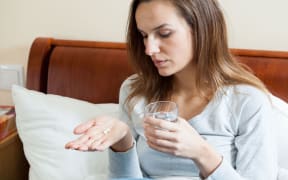 Woman with flu taking pills