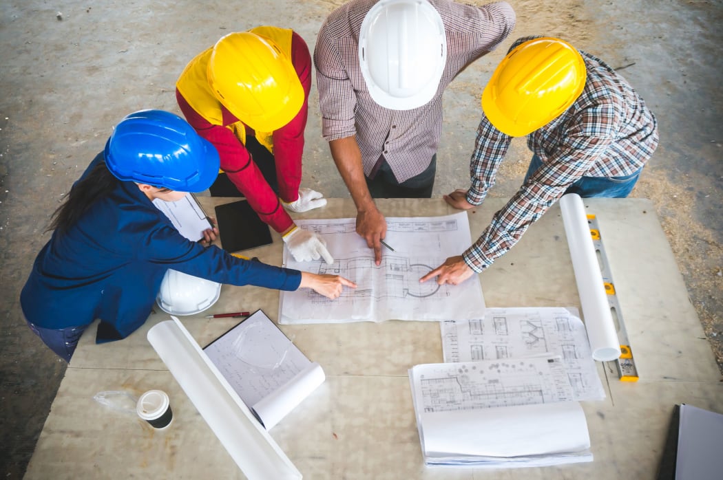 Engineer and foreman meeting at site with blueprint