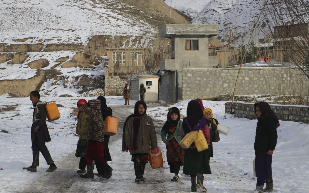 Children carry containers to fetch drinking water in Afghanistan's Yaftal Sufla district of Badakhshan Province on 18 January, 2023.